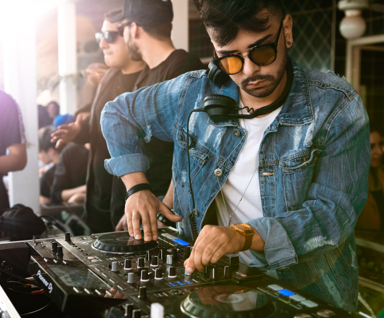 Mann, Der Blaue Jeansjacke Trägt, Während Sie Schwarzen Dj Controller Verwenden